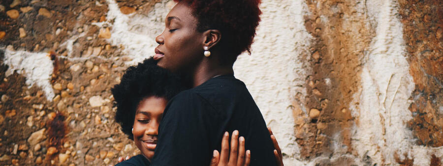 Yound Black boy hugging mother