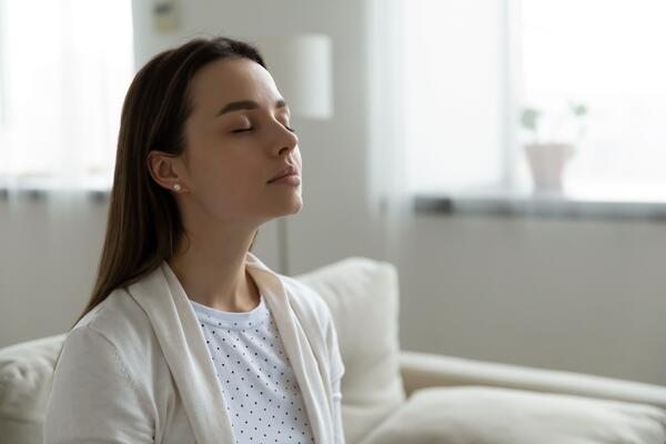 Person sitting on a couch with eyes closed